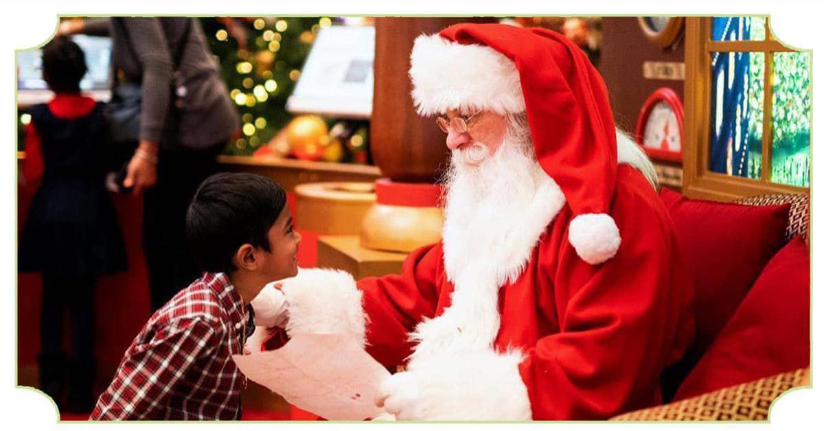 Le Père Noël, bienveillant, avec un enfant qui lui remet sa liste